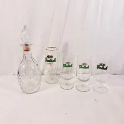 Sale Photo Thumbnail #186: Vintage cut glass decanter with glass stopper alongside a set of four Grolsch branded beer glasses.