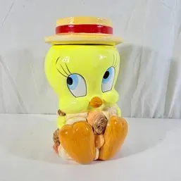 Sale Photo Thumbnail #260: Vintage Warner Bros. Tweety Bird ceramic cookie jar featuring Tweety wearing a straw hat and holding cookies.