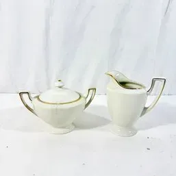 Sale Photo Thumbnail #212: Vintage white porcelain creamer and covered sugar bowl set with gold rim accents and geometric handles.
