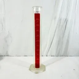 Sale Photo Thumbnail #70: Vintage Pyrex 1000 mL glass graduated cylinder with red scale markings and a hexagonal base.