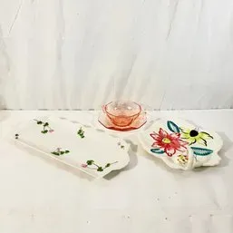 Sale Photo Thumbnail #51: Collection of vintage servingware, including a long hand-painted floral tray, a small pink Depression glass cup and saucer set, and a brightly painted floral dish with a looped handle.