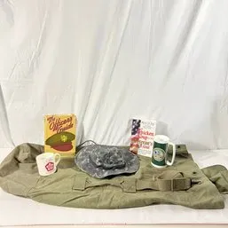 Sale Photo Thumbnail #132: Collection of military-themed memorabilia including an olive drab canvas bag, boonie hat, copy of 'The Officer's Guide', a 'Chicken Soup for the Veteran's Soul' book, and ceramic mugs.