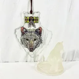 Sale Photo Thumbnail #253: Hanging acrylic suncatcher featuring a printed wolf illustration with Native American-inspired motifs, displayed next to a frosted glass wolf figurine.