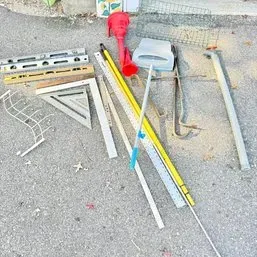 Sale Photo Thumbnail #16: Assortment of hand tools and hardware, including levels, framing squares, yardsticks, clamps, and wire shelving components.