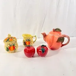 Sale Photo Thumbnail #40: Vintage ceramic fruit-themed table accessories, including an apple-shaped teapot, red apple salt and pepper shakers, and yellow basket-weave peach creamer and sugar bowl set.