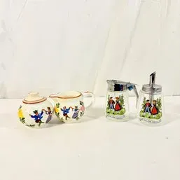 Sale Photo Thumbnail #68: Vintage European folk art-themed tableware set, including ceramic creamer and sugar bowl alongside two glass dispensers with metal pour tops.