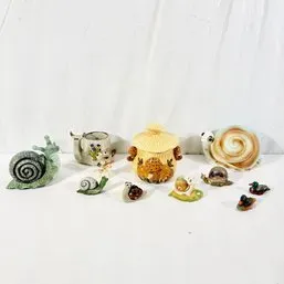 Sale Photo Thumbnail #116: Collection of decorative snail figurines and small ceramic novelties in various sizes, styles, and materials.
