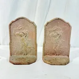 Sale Photo Thumbnail #224: Pair of vintage cast metal bookends featuring relief carvings of classical figures with a weathered, distressed finish.