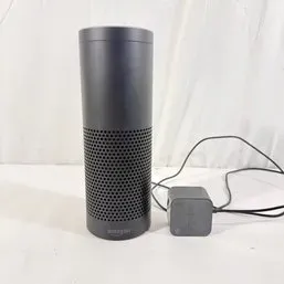 Sale Photo Thumbnail #96: First-generation Amazon Echo cylindrical smart speaker in black, complete with its original power adapter.