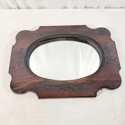 Sale Photo Thumbnail #122: Vintage dark wood framed wall mirror with carved floral accents and an oval mirror insert.