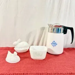 Sale Photo Thumbnail #204: Vintage Corning Ware Cornflower Blue coffee percolator, Pyrex Butterprint square dish, and white milk glass rabbit-on-nest trinket dishes displayed on a red cloth.