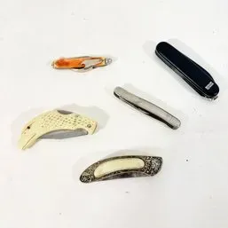 Sale Photo Thumbnail #178: Collection of five vintage pocket knives, including a dolphin-shaped knife, a metal pen knife, and a black multi-tool.