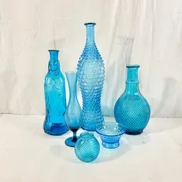 Sale Photo Thumbnail #57: Collection of vibrant blue glass vessels, including hobnail, diamond-patterned, and textured vases and a small dish.