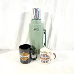 Sale Photo Thumbnail #192: Vintage green Stanley insulated vacuum thermos paired with a black Harley-Davidson coffee mug and a printed ceramic mug.