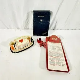 Sale Photo Thumbnail #22: Vintage game accessories including a playing-card-themed ceramic ash tray set, a classic Rook card game set in a black case, and a red bridge scoring clipboard.