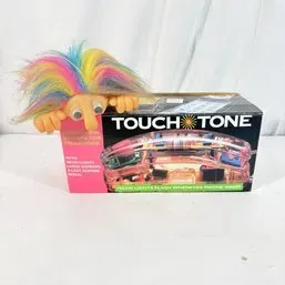 Sale Photo Thumbnail #35: Vintage 1990s Touch Tone neon light-up telephone in original box, featuring a rainbow-haired troll doll clip attachment.