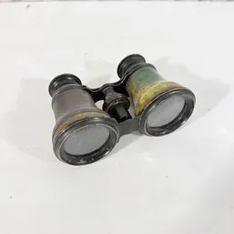 Sale Photo Thumbnail #200: Antique brass and leather opera glasses featuring a central focusing wheel, displaying a aged patina consistent with turn-of-the-century manufacture.