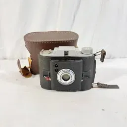 Sale Photo Thumbnail #198: Vintage Ansco Flash Clipper 620 roll film camera with a black and grey body, accompanied by its original brown leather carrying case.