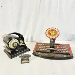 Sale Photo Thumbnail #216: Vintage mechanical check writer, Marx tin toy Dial Typewriter, and a miniature typewriter novelty item showing age-appropriate wear.