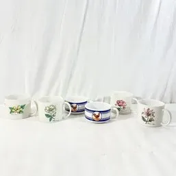 Sale Photo Thumbnail #155: Set of seven ceramic mugs featuring floral motifs and rooster designs against a white background.