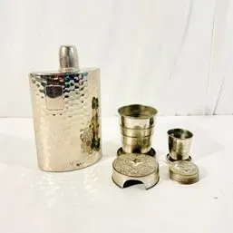 Sale Photo Thumbnail #109: Vintage hammered metal flask set featuring a curved liquor flask paired with two collapsible metal shot cups.