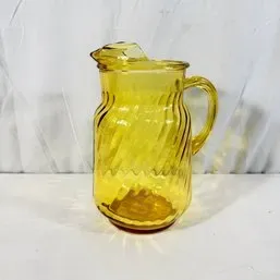 Sale Photo Thumbnail #64: Vintage yellow amber glass pitcher with a diagonal swirl pattern and molded handle, mid-20th century.