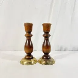Sale Photo Thumbnail #58: Pair of vintage turned wood candlesticks featuring brass bases and a warm brown finish.