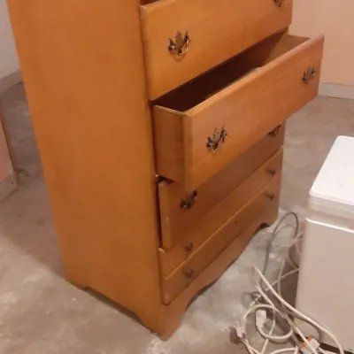 Vintage light pine tallboy dresser featuring five drawers with classic brass bail pulls and a scalloped base.