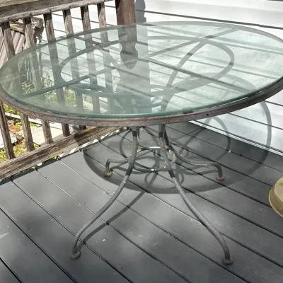 Oval Glass-Top Patio Dining Table with Decorative Metal Scrollwork Base