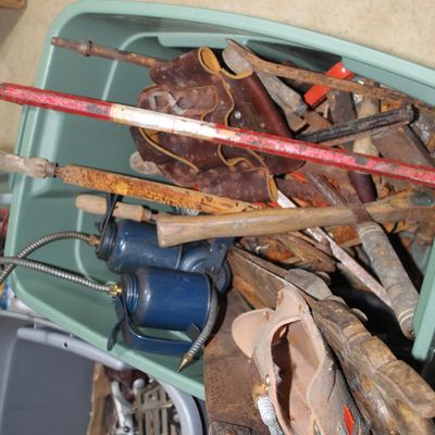 Sale Photo Thumbnail #101: Plastic storage tote filled with assorted vintage hand tools, including oil cans, saws, leather tool pouches, and rusted hardware.