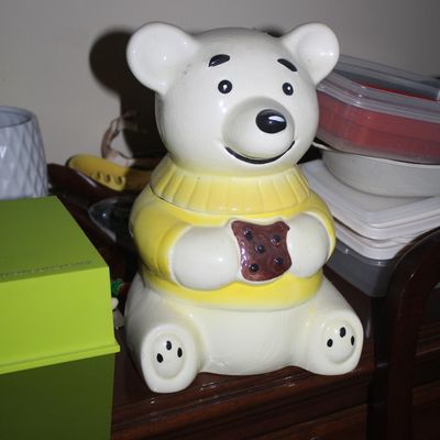 Sale Photo Thumbnail #39: Vintage ceramic polar bear cookie jar featuring a bear in a yellow sweater holding a chocolate chip cookie.