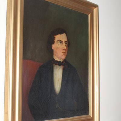 Sale Photo Thumbnail #38: Antique 19th-century oil portrait painting of a gentleman in a dark suit with a bow tie, housed in a molded gilt wooden frame.