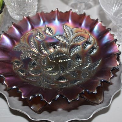 Sale Photo Thumbnail #25: Early 20th-century Fenton purple carnival glass bowl featuring a strawberry pattern with a ruffled, saw-tooth edge and rich iridescent sheen.