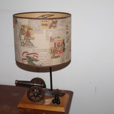 Sale Photo Thumbnail #78: Vintage American Bicentennial themed novelty table lamp featuring a wooden canon base and printed drum shade, circa 1970s.