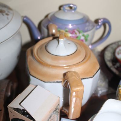 Sale Photo Thumbnail #50: Vintage iridescent lusterware teapots, including an peach-and-white art deco style teapot and a floral purple-accented teapot.