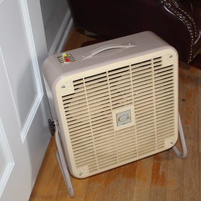 Sale Photo Thumbnail #98: Vintage General Electric metal box fan with a cream grille and carrying handle, sitting on a tubular stand.