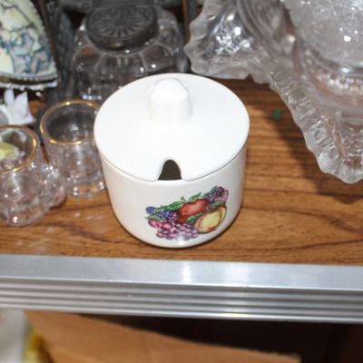 Sale Photo Thumbnail #7: Small white ceramic lidded sugar bowl with a fruit motif, displayed alongside miniature glass steins and vintage cut glassware.