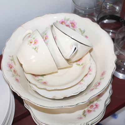 Sale Photo Thumbnail #17: Vintage floral porcelain teacups, saucers, and serving bowls with silver rims stacked alongside clear glassware.