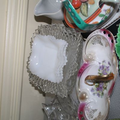 Sale Photo Thumbnail #57: Collection of vintage glassware and ceramics, featuring white milk glass candy dishes, clear cut-glass bowls, a floral porcelain serving dish with gold-tone handle, and a green leaf dish.