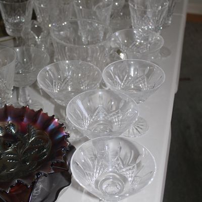 Sale Photo Thumbnail #27: Large collection of vintage crystal glassware, featuring cut-glass coupe cocktail glasses, goblets, and a dark iridescent carnival glass ruffled dish.
