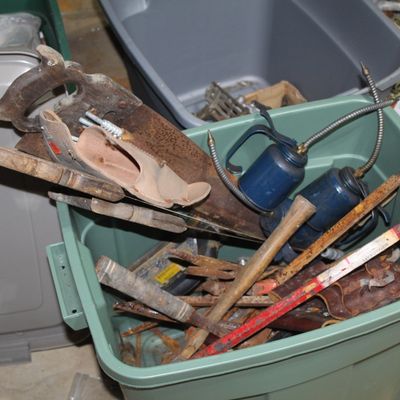 Sale Photo Thumbnail #99: Plastic storage bin filled with vintage hand tools, including hand saws, oil cans, pry bars, and wooden-handled tools.