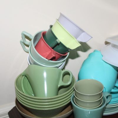 Sale Photo Thumbnail #45: Collection of vintage mid-century colorful Tupperware and plastic melamine dishware, including stacked cups, saucers, and pitcher pieces.