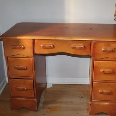 Sale Photo Thumbnail #95: Mid-century maple vanity desk featuring seven drawers with wooden bar pulls and a contoured kneehole center.