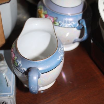 Sale Photo Thumbnail #48: Vintage lusterware creamer and matching covered sugar bowl with hand-painted floral trim and blue luster accents.
