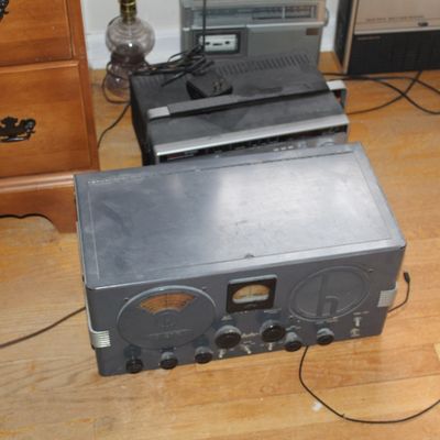 Sale Photo Thumbnail #81: Vintage Hallicrafters shortwave radio receiver, mid-20th century, displayed on a wooden floor alongside other vintage audio electronics.