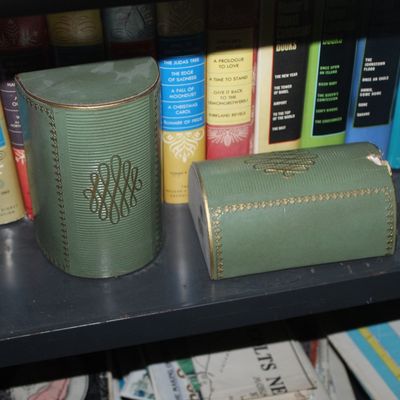 Sale Photo Thumbnail #91: Pair of vintage green faux-leather book-style bookends with gilt details, displayed on a bookshelf alongside hardback books.
