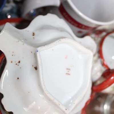 Sale Photo Thumbnail #11: Underside of a vintage leaf-shaped ceramic dish stamped Made in Japan, surrounded by assorted tableware.
