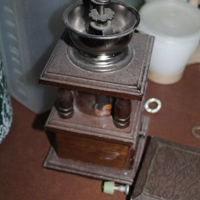 Sale Photo Thumbnail #37: Vintage manual wooden coffee grinder featuring a metal hopper, hand crank, turned wooden corner posts, and a catch drawer.