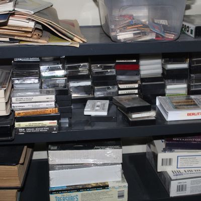Sale Photo Thumbnail #90: Shelves filled with vintage cassette tapes, boxed software, books, and various print media.