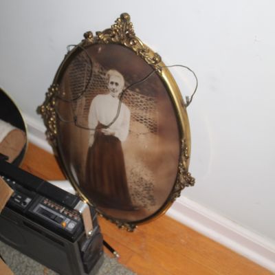 Sale Photo Thumbnail #31: Antique oval portrait of a woman housed in an ornate brass frame with convex glass.